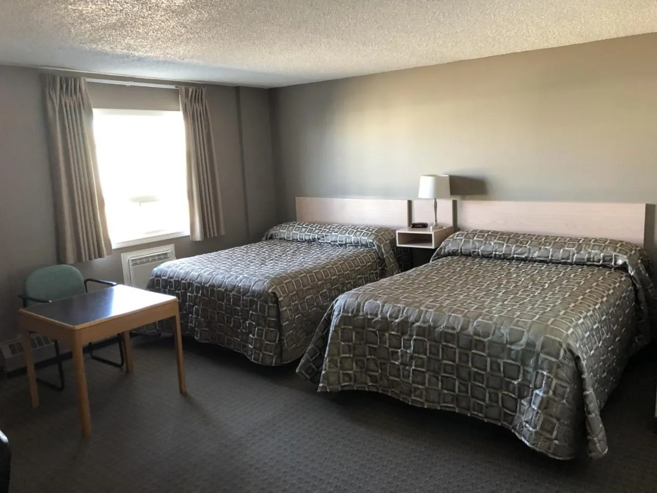 Bed in Arbour Ridge Inn & Suites