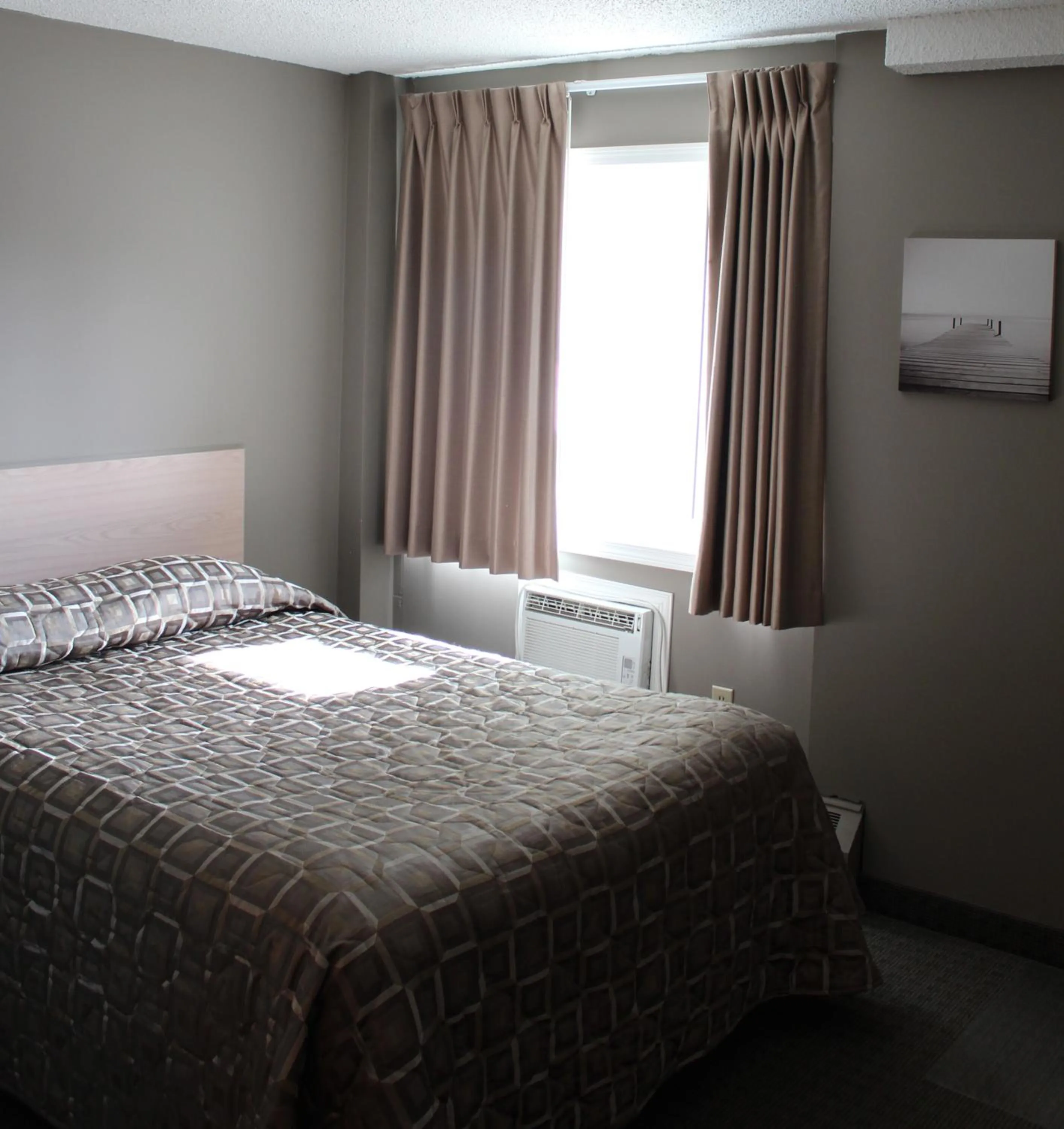 Bed in Arbour Ridge Inn & Suites