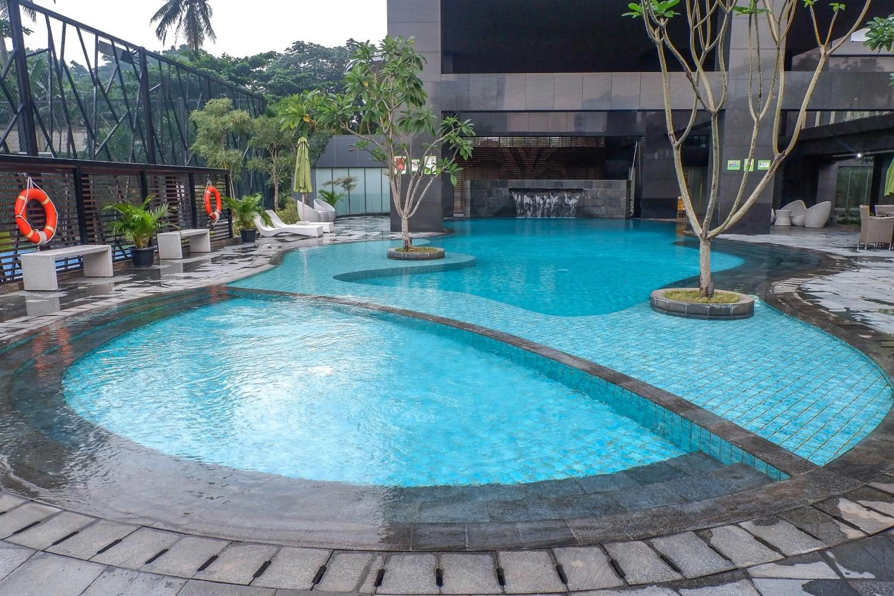 Swimming pool in 2BR with Study Room at L'Avenue Apartment By Travelio