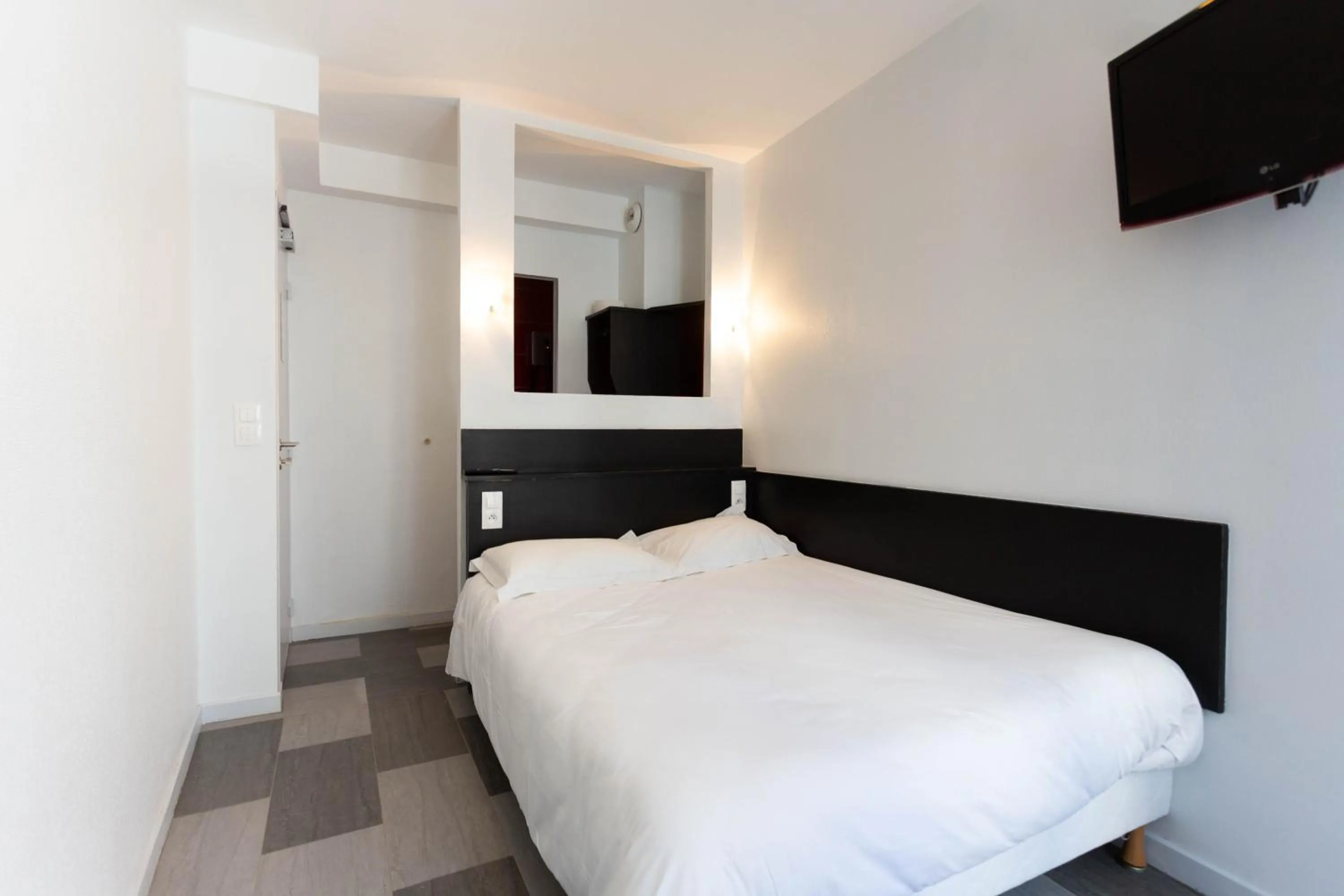 Bed in Hotel Mimosa Paris