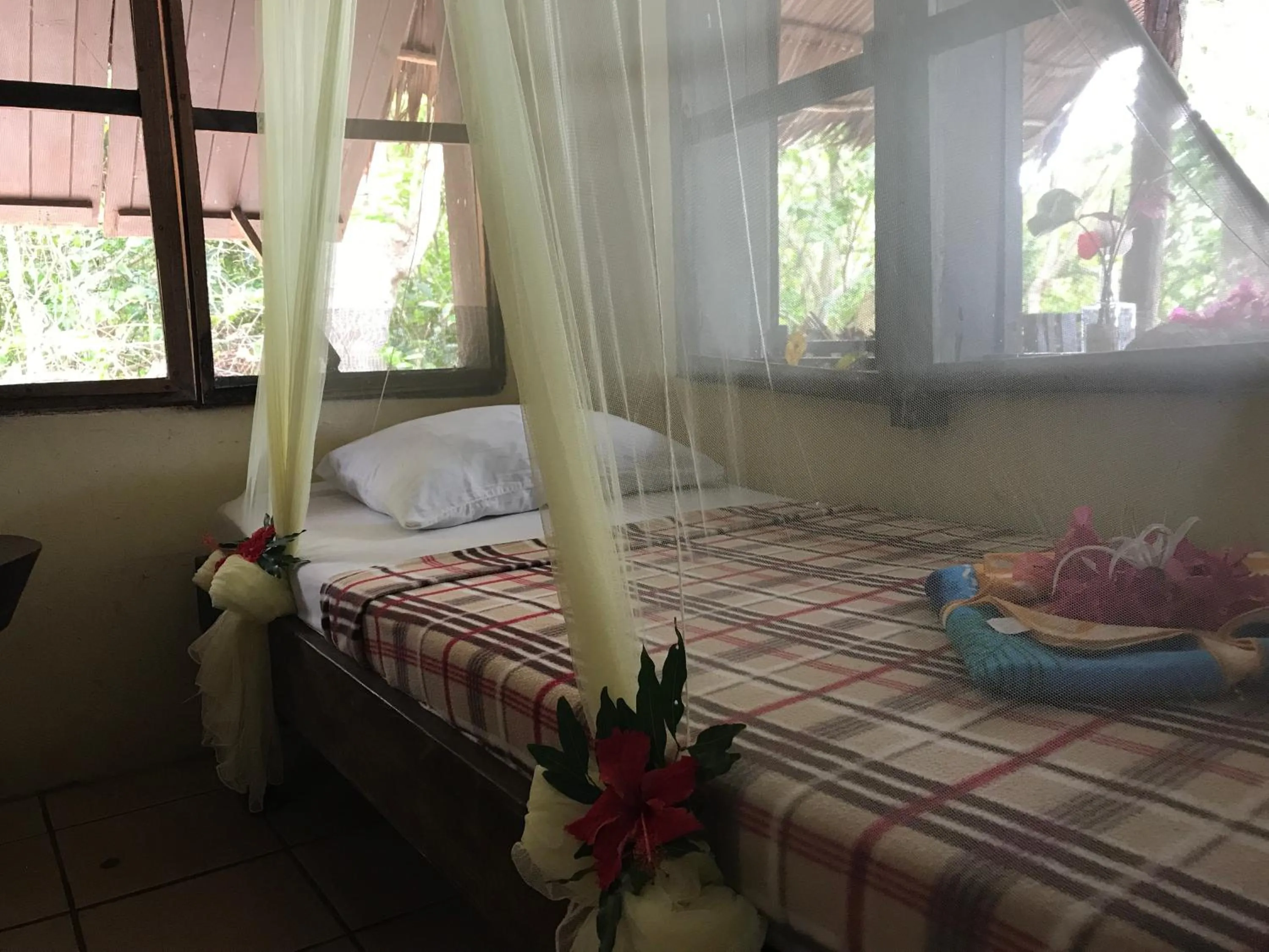 Bed in Tranquility Island Eco Dive Resort