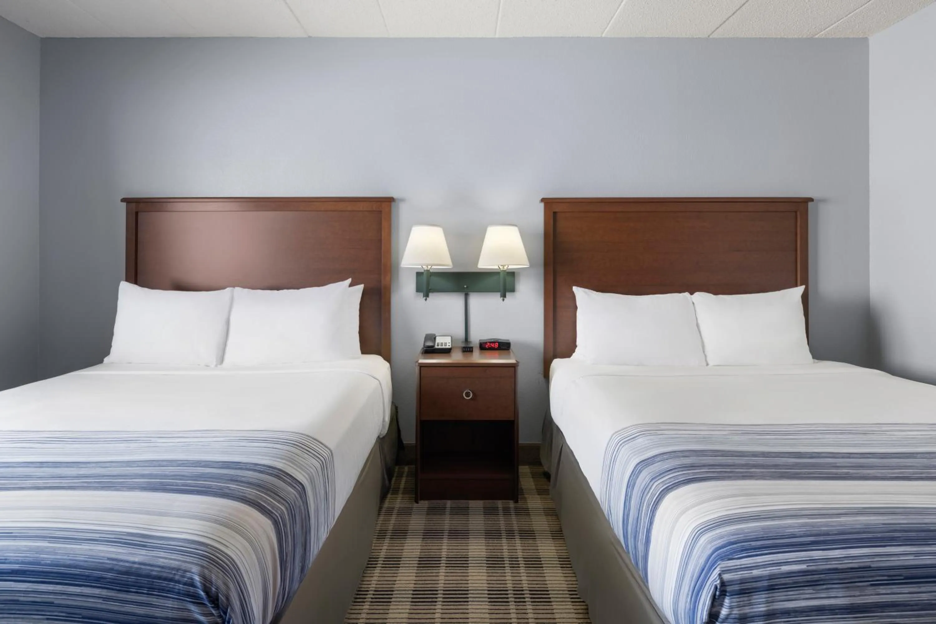 Bed in AmericInn by Wyndham Stuart