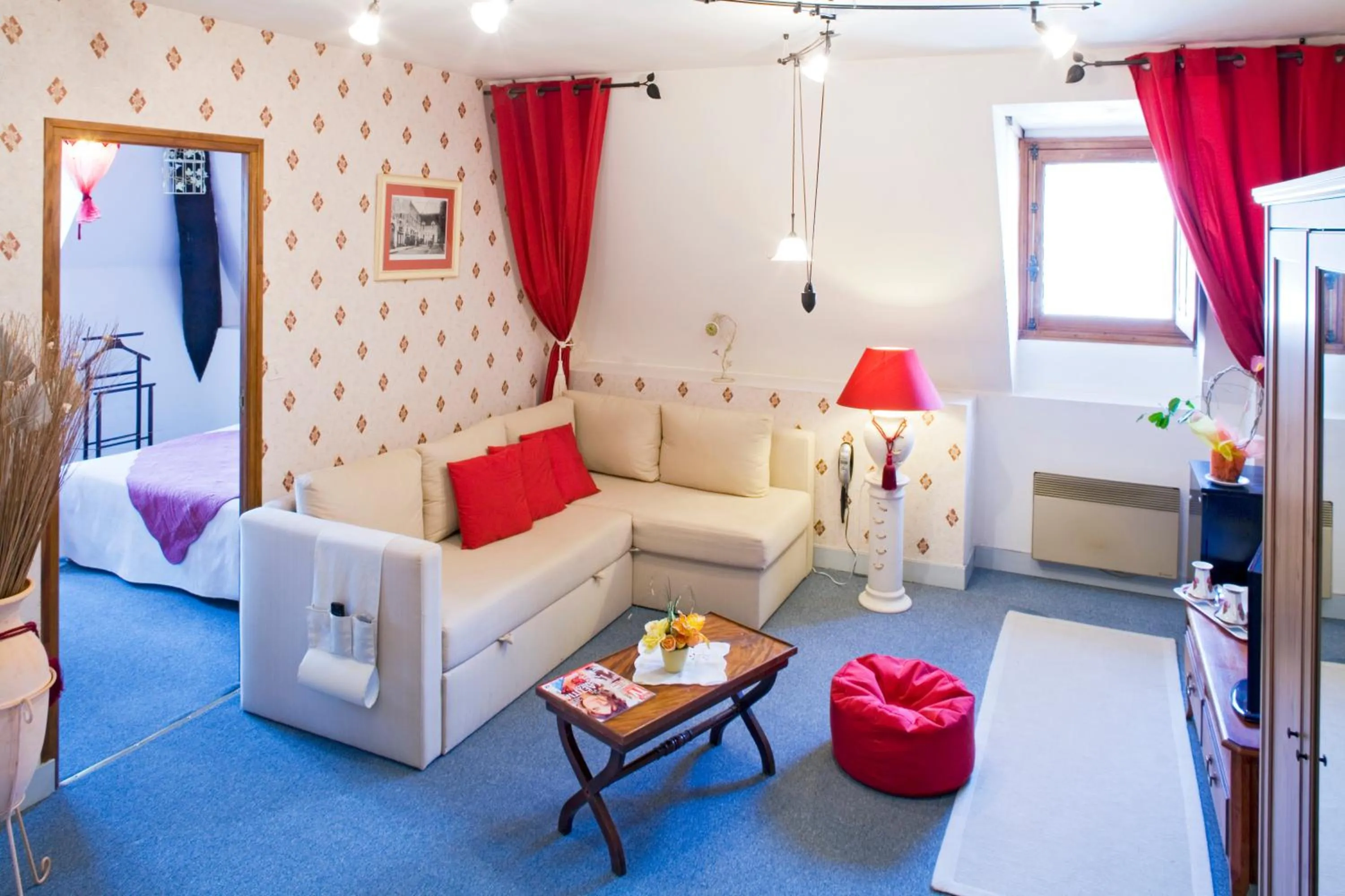 Living room, Bed in Logis Hôtel Restaurant Le Puits Doré