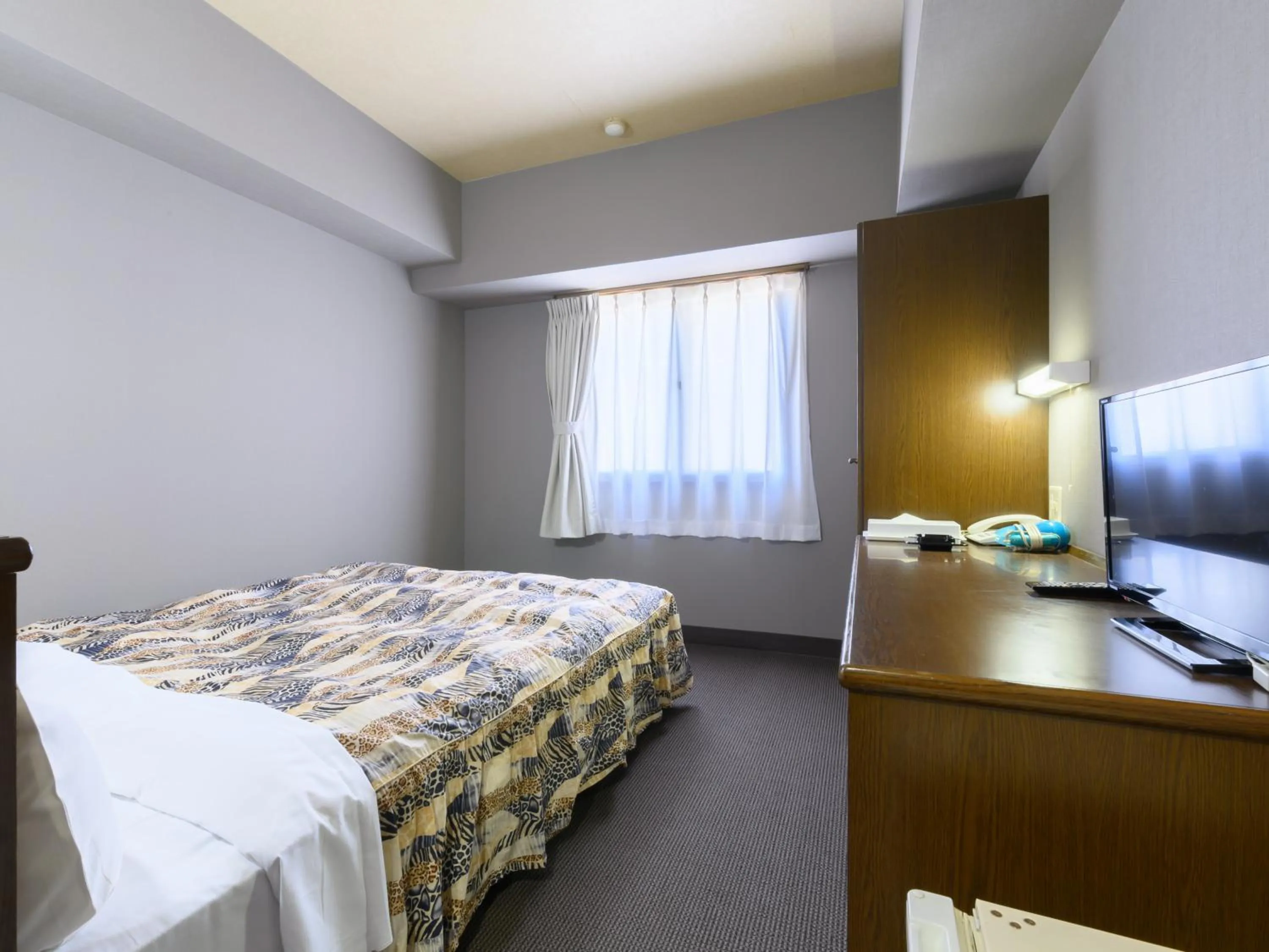 Bed in Tabist IWATA Station Hotel