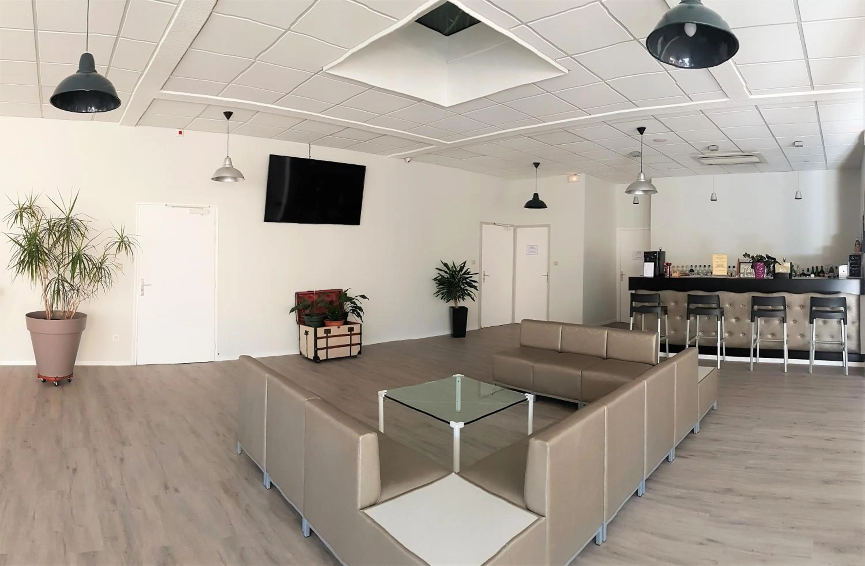 Communal lounge/ TV room in Hôtel La Bérangère