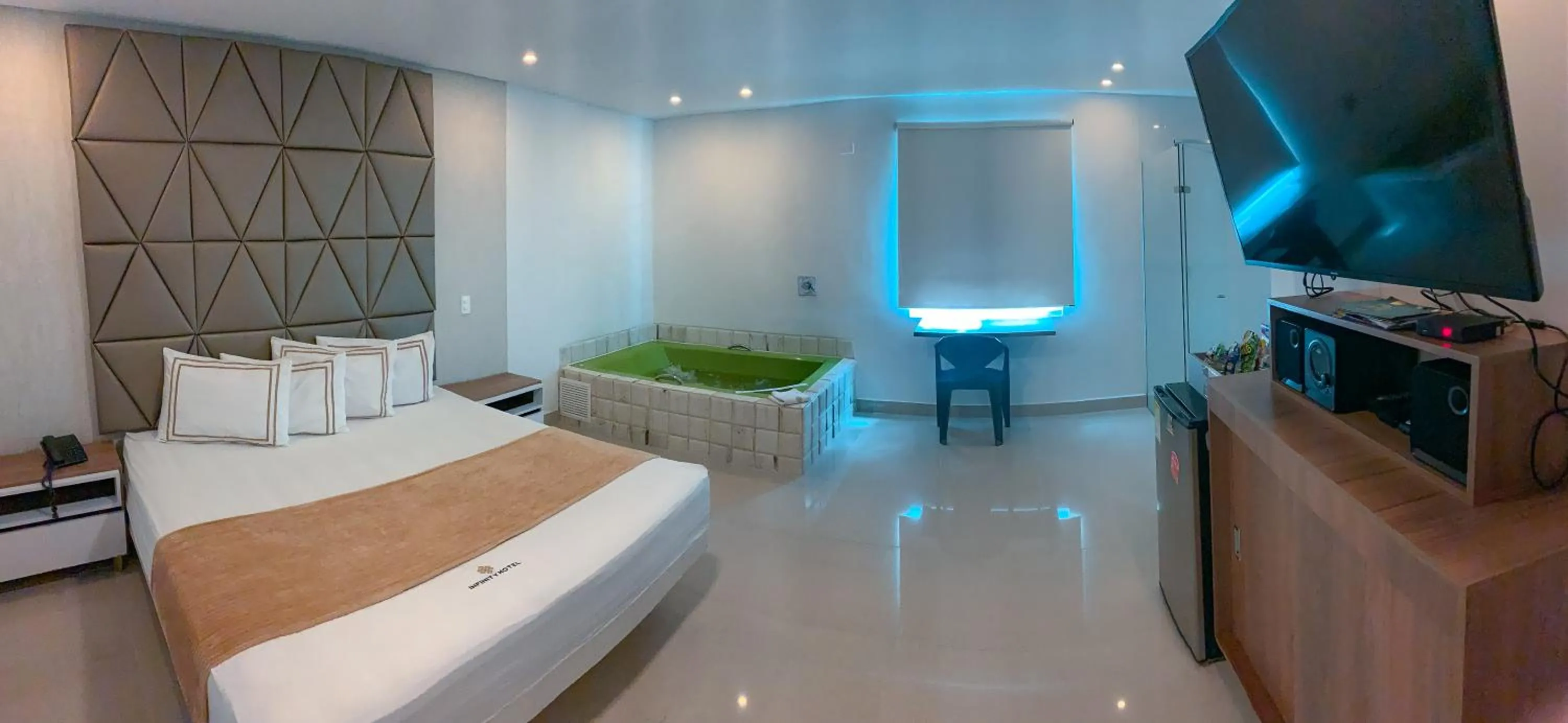 Communal lounge/ TV room, Bed in Infinity Hotel