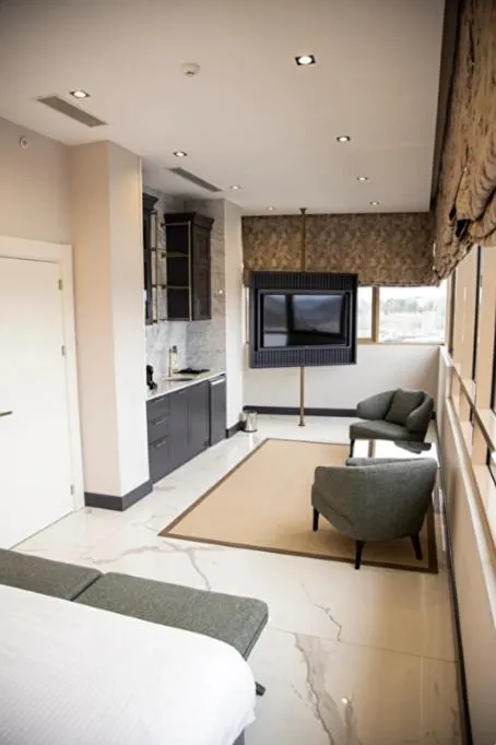 Communal lounge/ TV room, Bed in Hilly Hotel