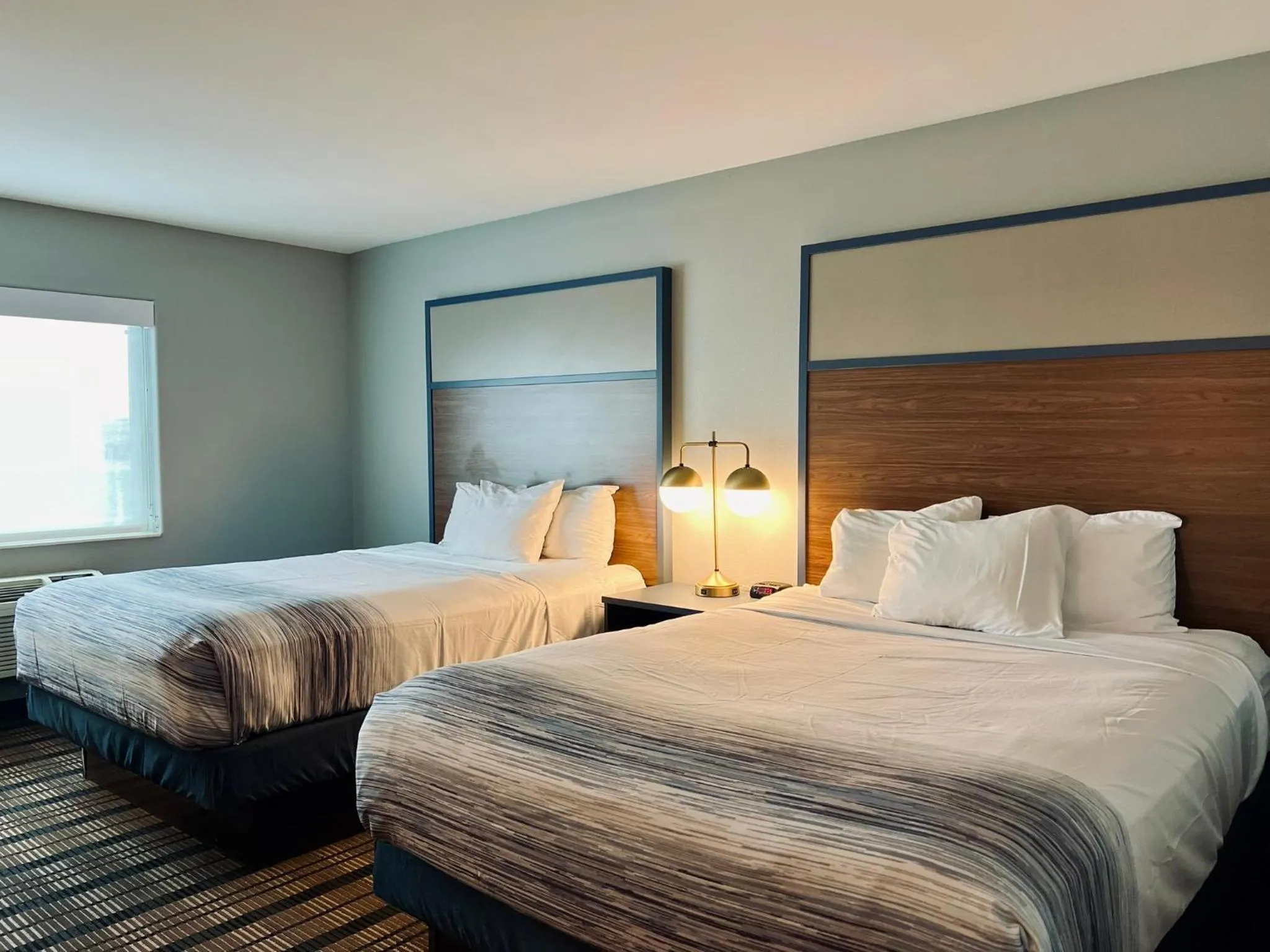 Bed in AmericInn by Wyndham Beaver Dam