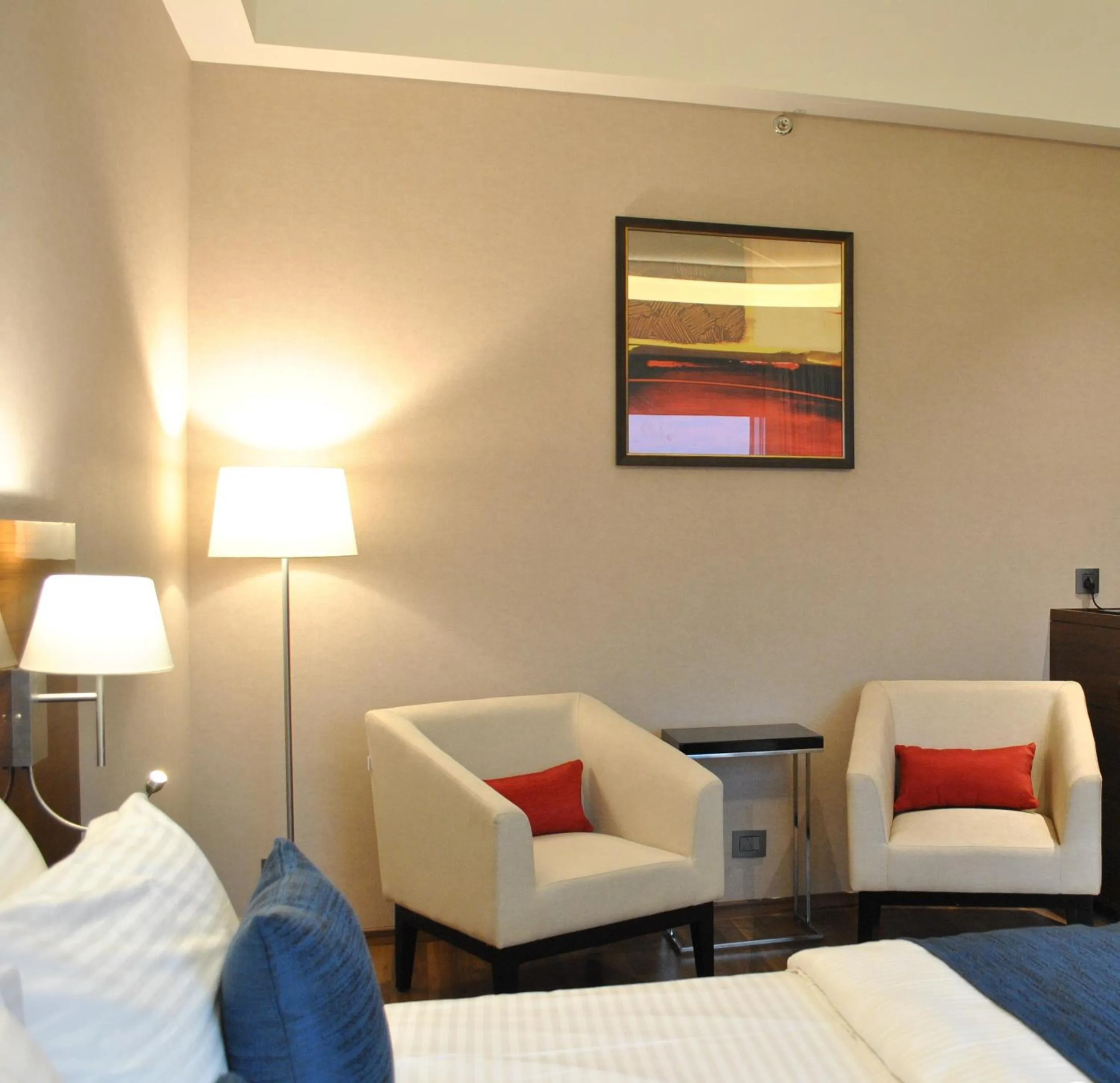 Seating area, Bed in Ramada by Wyndham Gandhidham Shinay