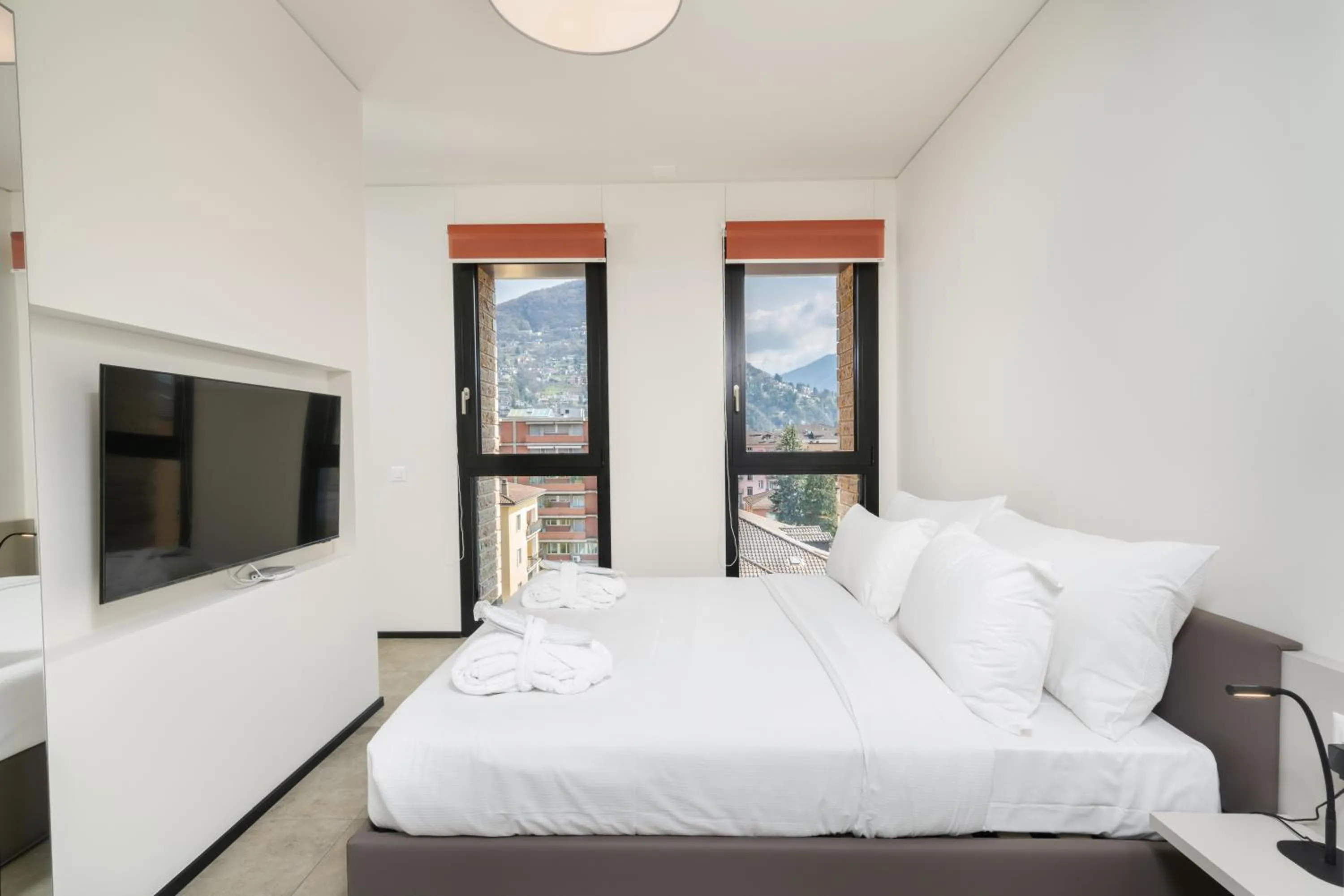 Communal lounge/ TV room, Bed in Swiss Hotel Apartments - Lugano