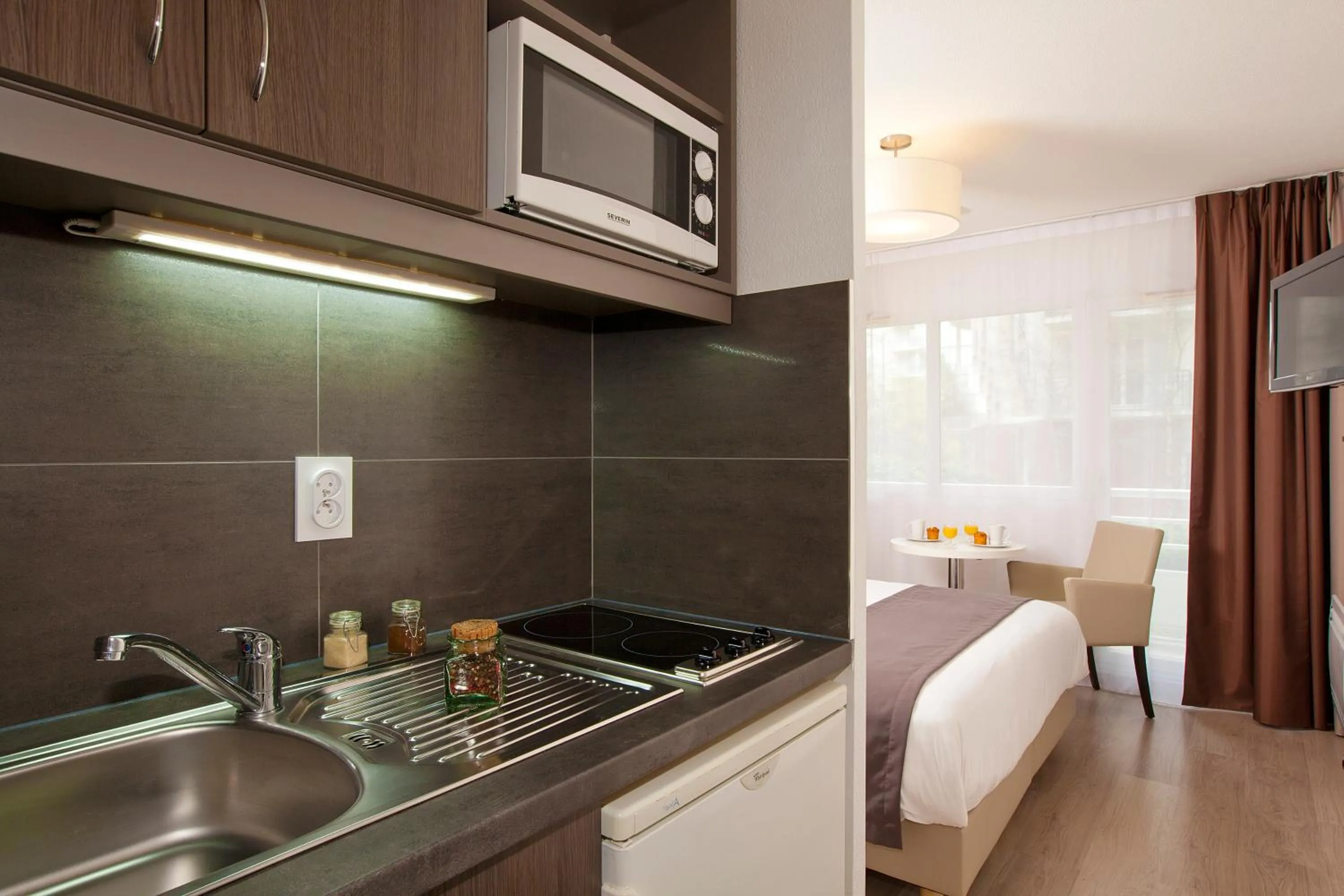 Kitchen or kitchenette, Bed in Séjours & Affaires Courbevoie Grande Arche