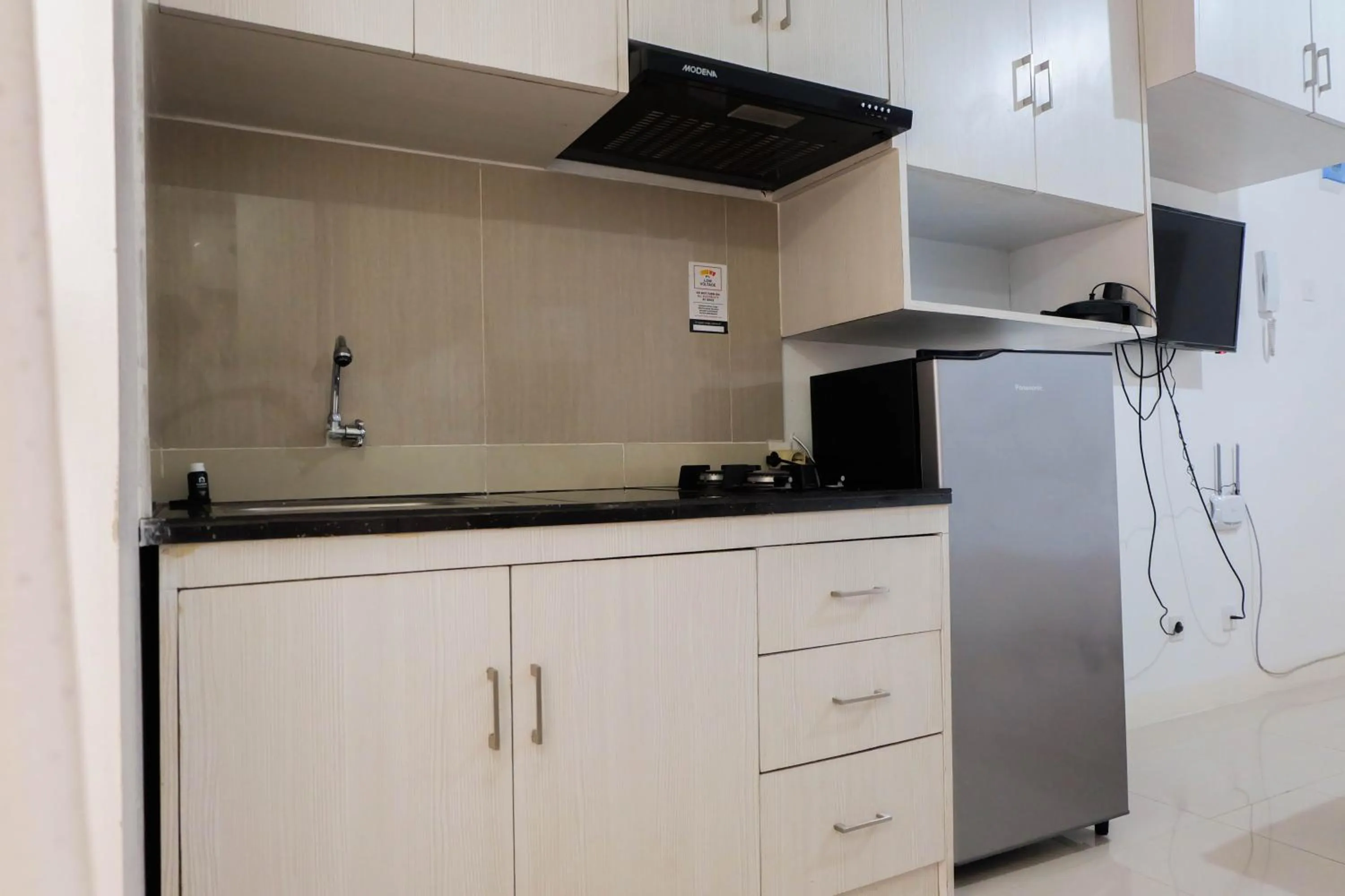 Kitchen or kitchenette in Tidy Studio Apartment at Bassura City near Shopping Mall By Travelio