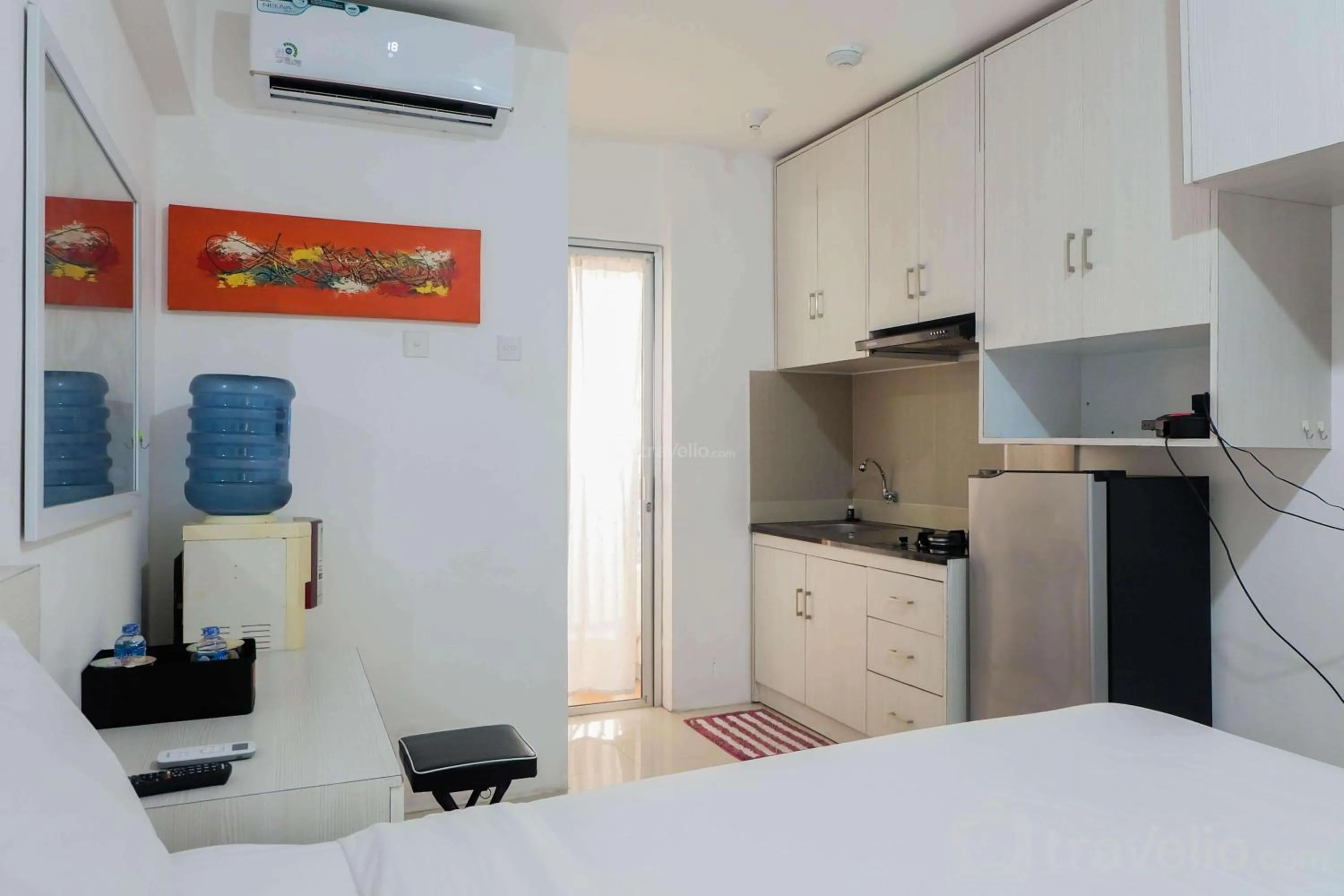 Kitchen or kitchenette, Bed in Tidy Studio Apartment at Bassura City near Shopping Mall By Travelio