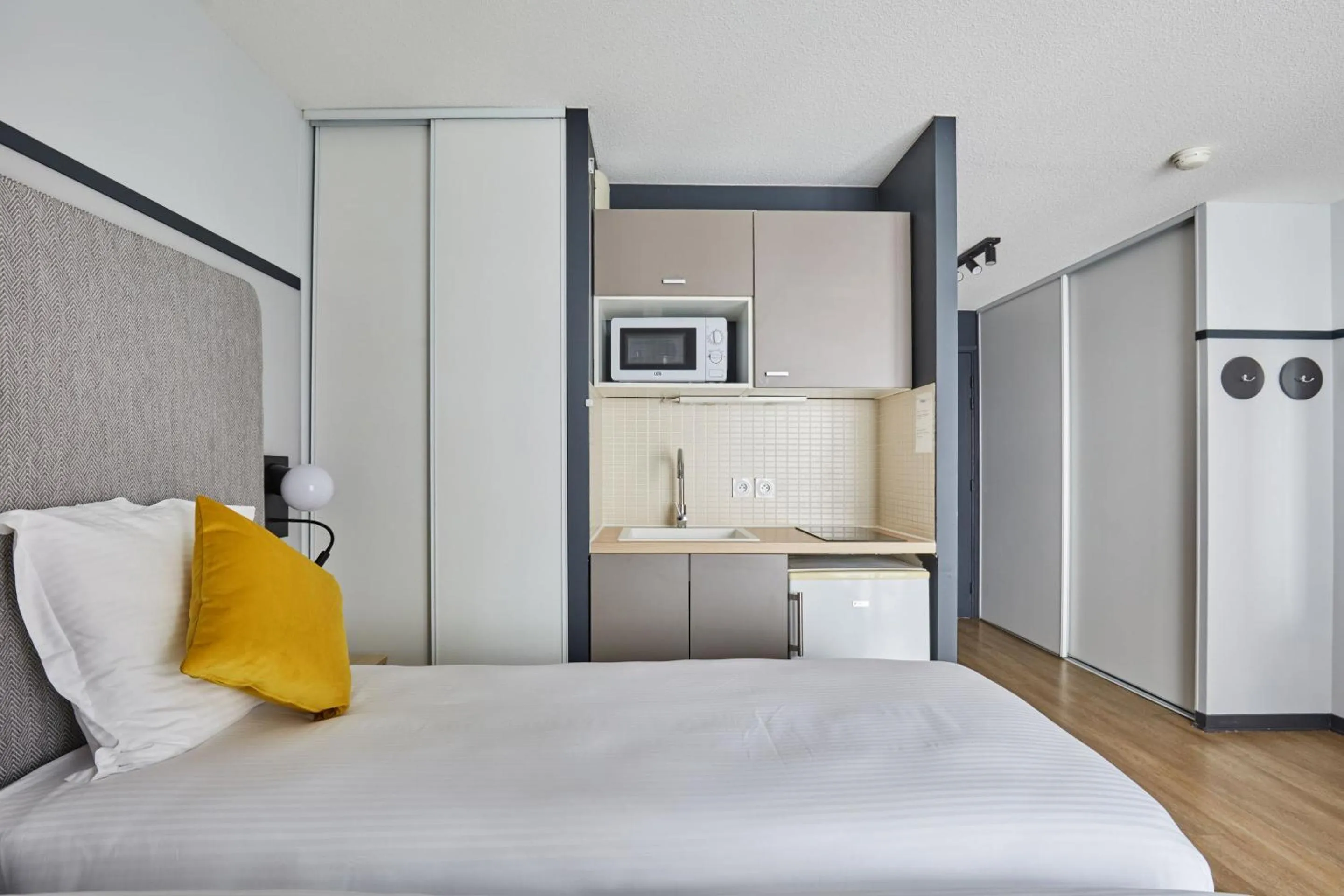 Kitchen or kitchenette, Bed in Appart'hôtel Odalys City - Lyon Centre Confluence