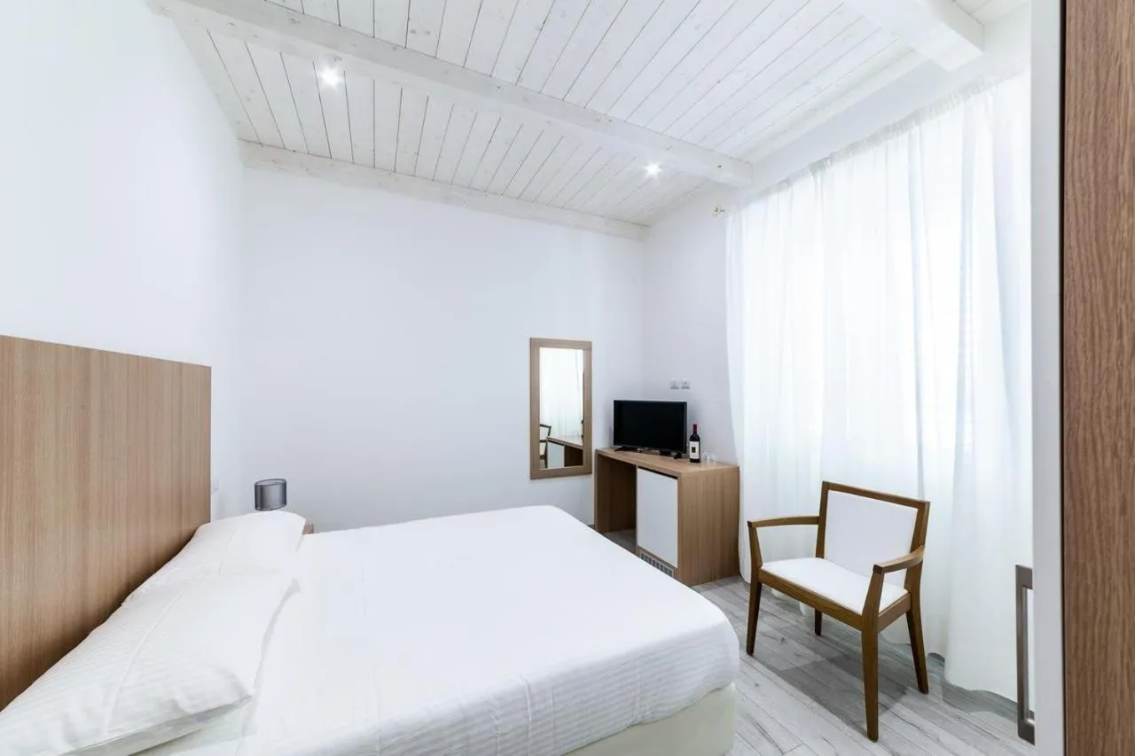 Bed in La Promenade Rooms & Suites