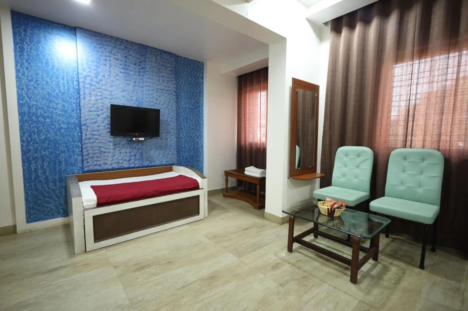 Communal lounge/ TV room, Bed in Saish Hotel Shirdi