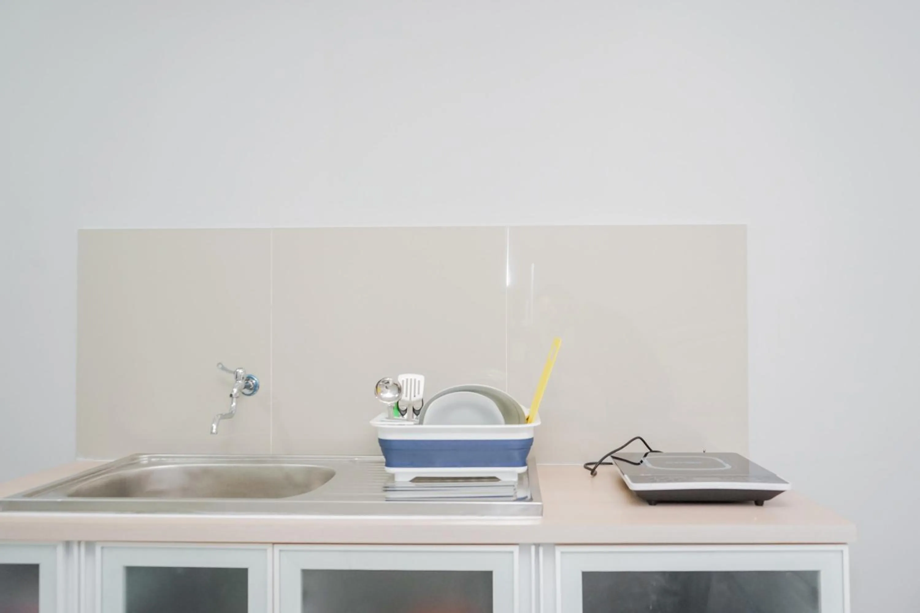 Kitchen or kitchenette in Fully Furnished Studio with Comfort Design Majestic Point Serpong Apartment By Travelio