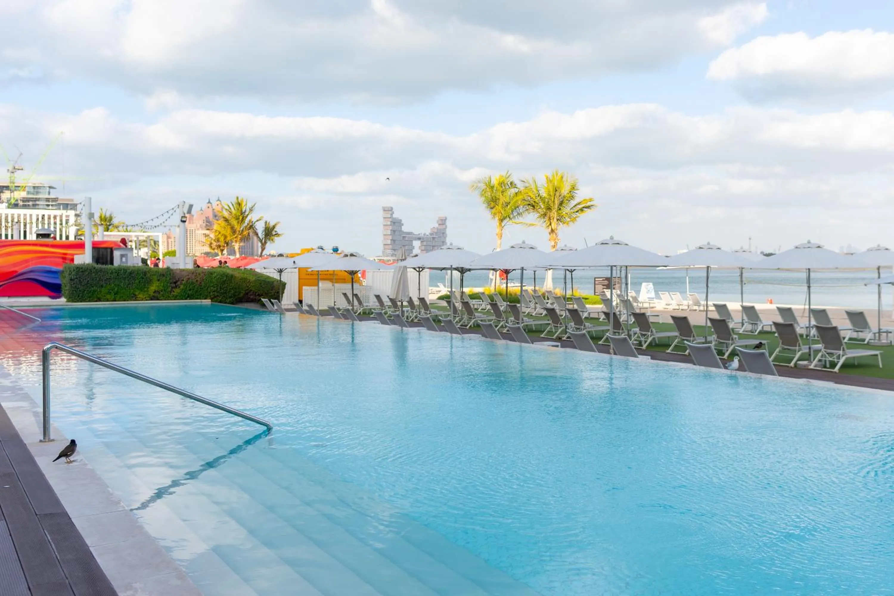 Swimming pool in Th8 Palm Dubai Beach Resort, Vignette Collection by IHG