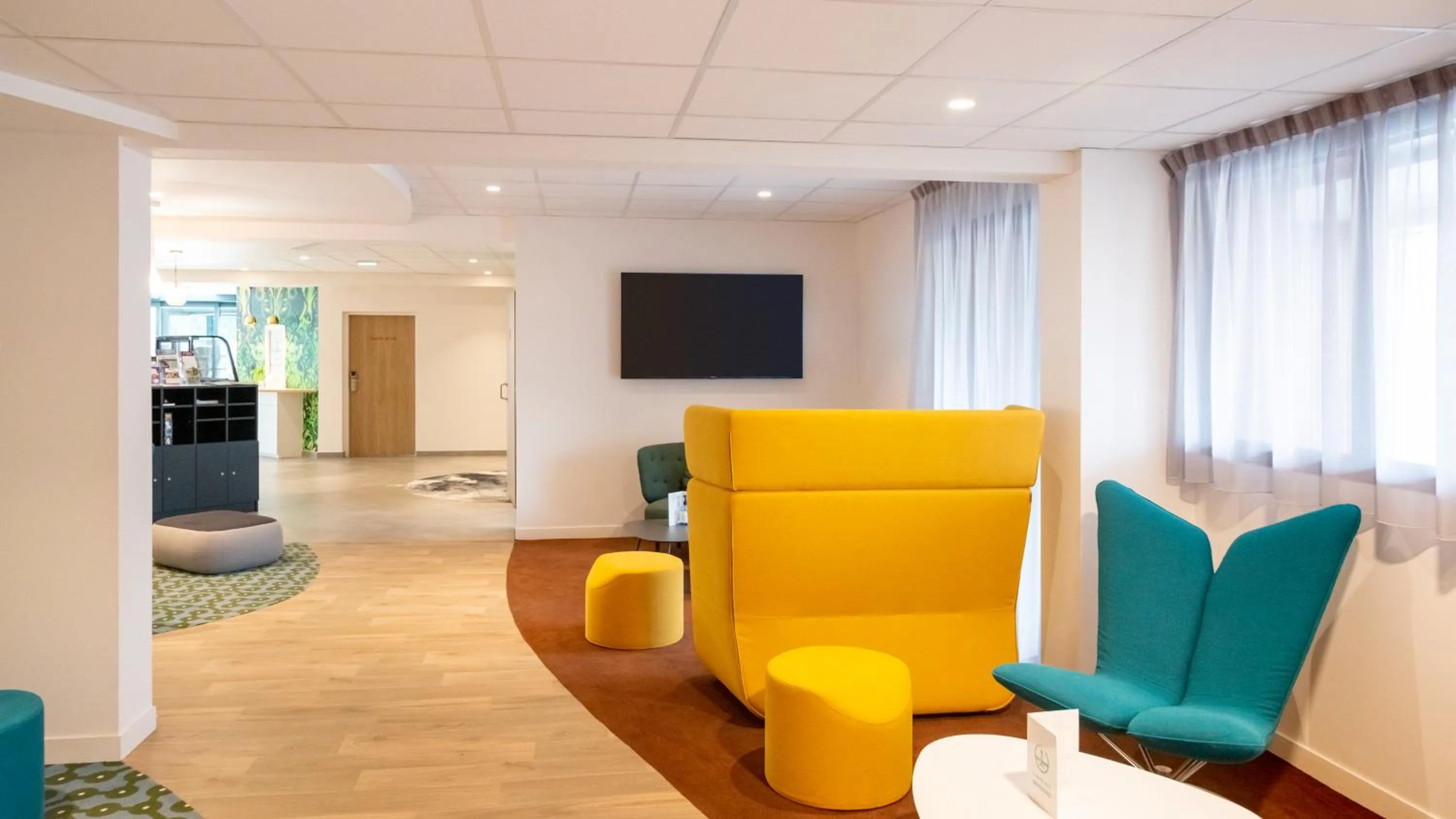 Communal lounge/ TV room in ibis Styles Fougeres