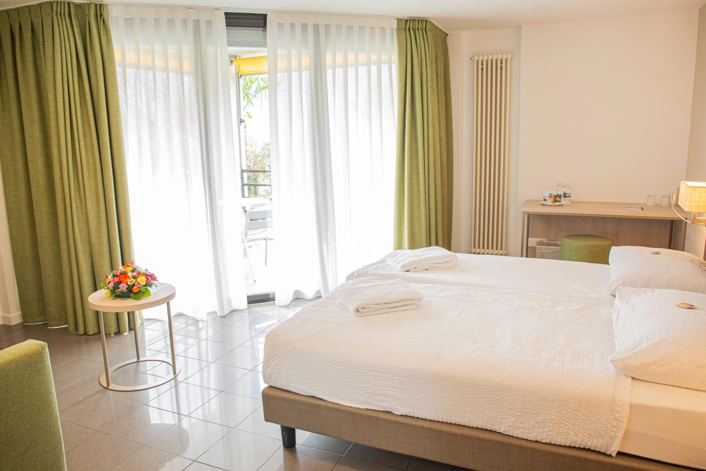 Communal lounge/ TV room, Bed in Hotel Nessi Locarno