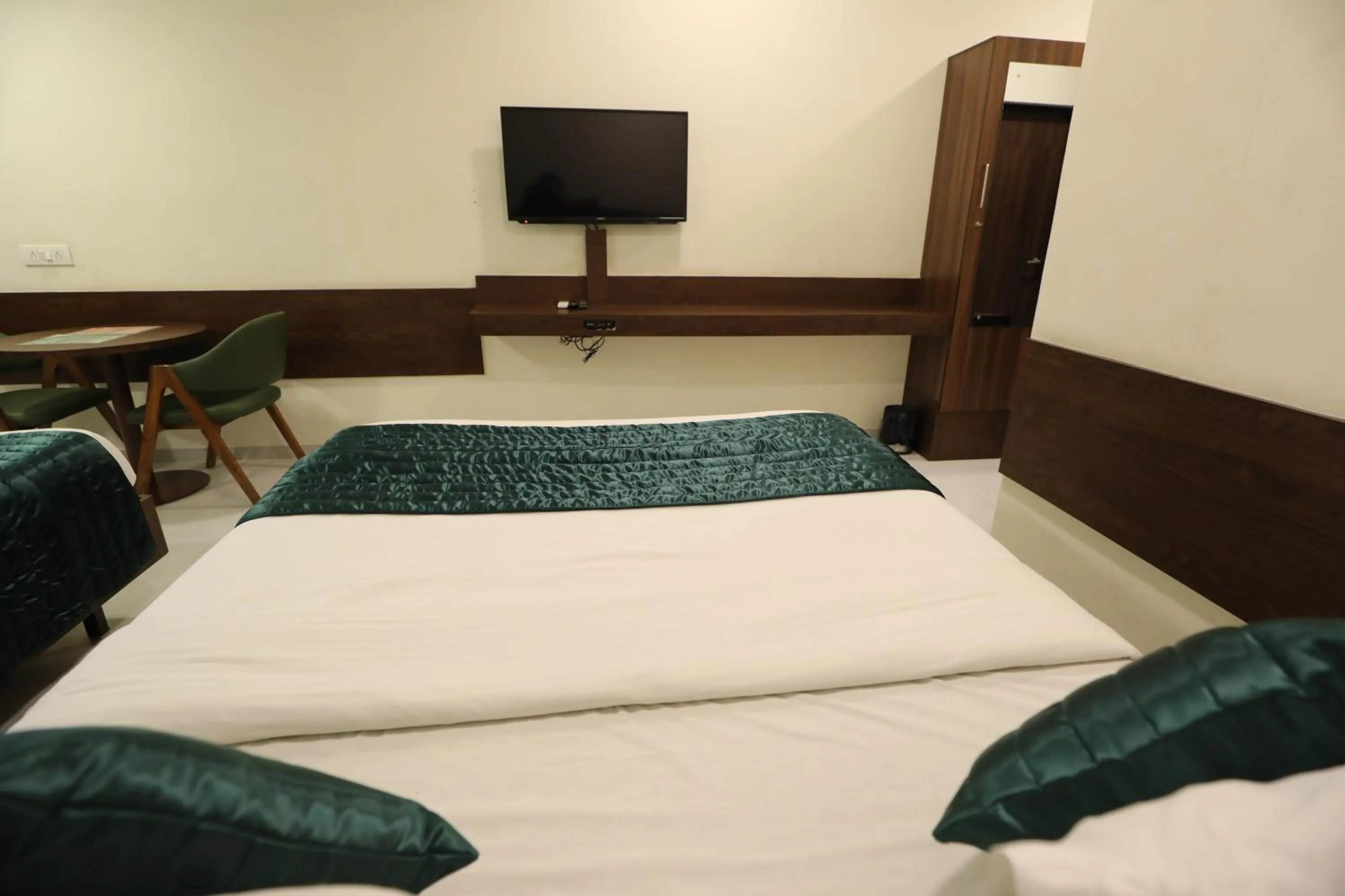 Communal lounge/ TV room, Bed in Greenotel Rooms Hazira, Surat
