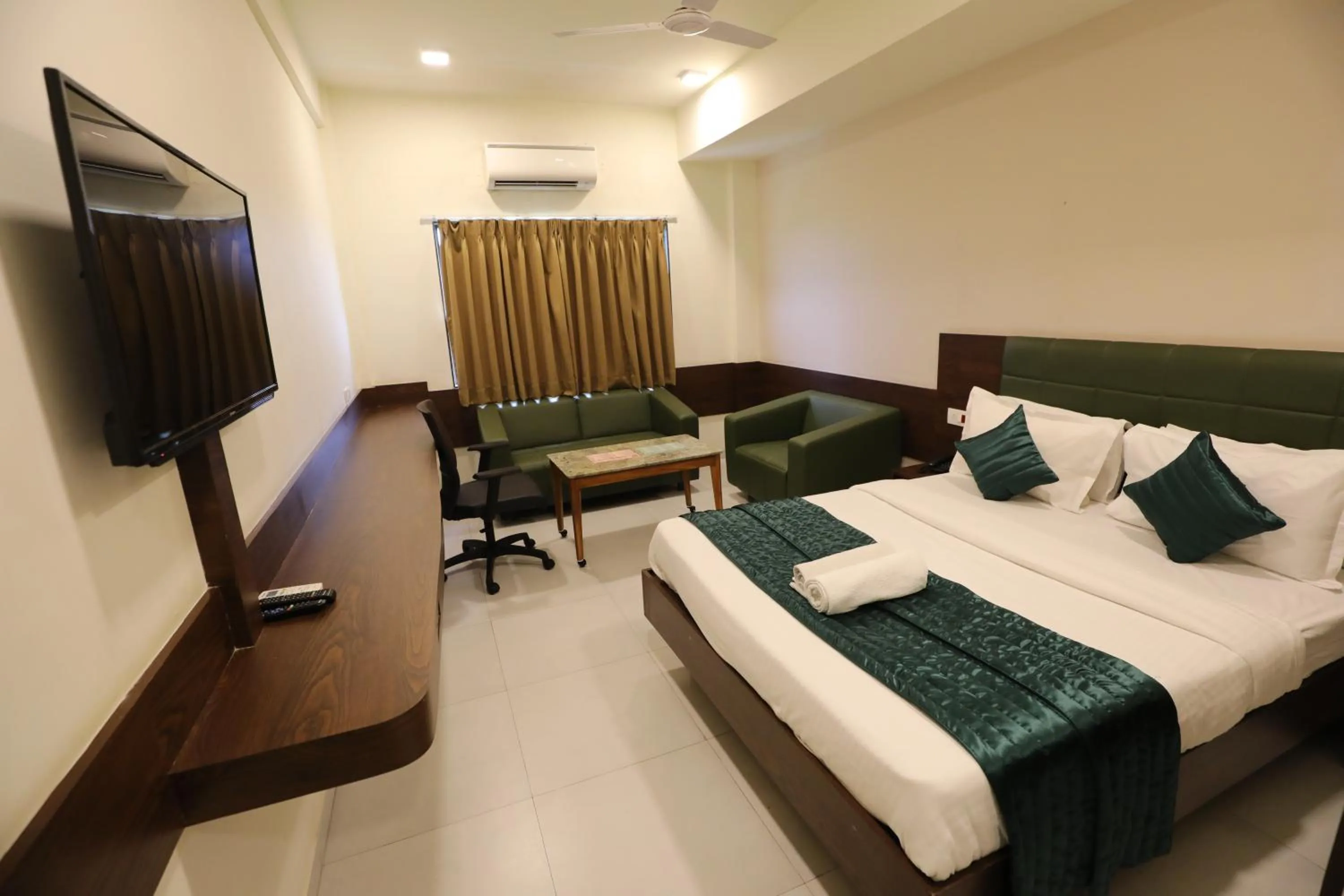 Communal lounge/ TV room, Bed in Greenotel Rooms Hazira, Surat