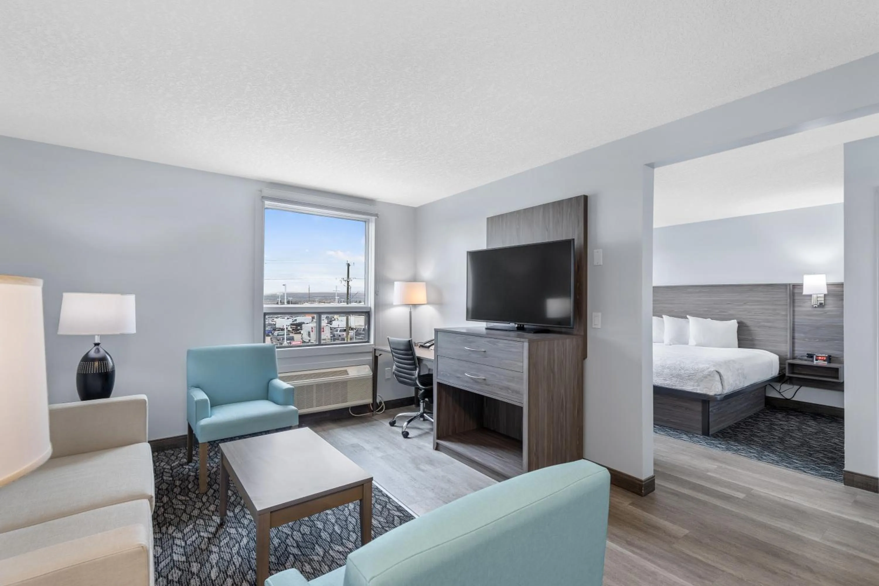 Living room, Bed in Emerald Hotel & Suites Calgary Airport