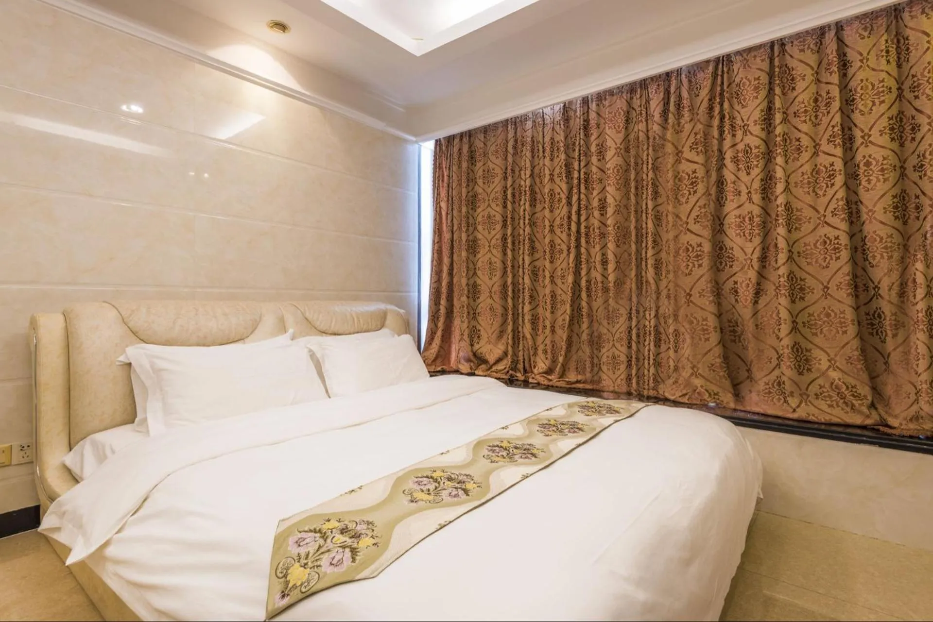 Bed in Grand Continental Apartment