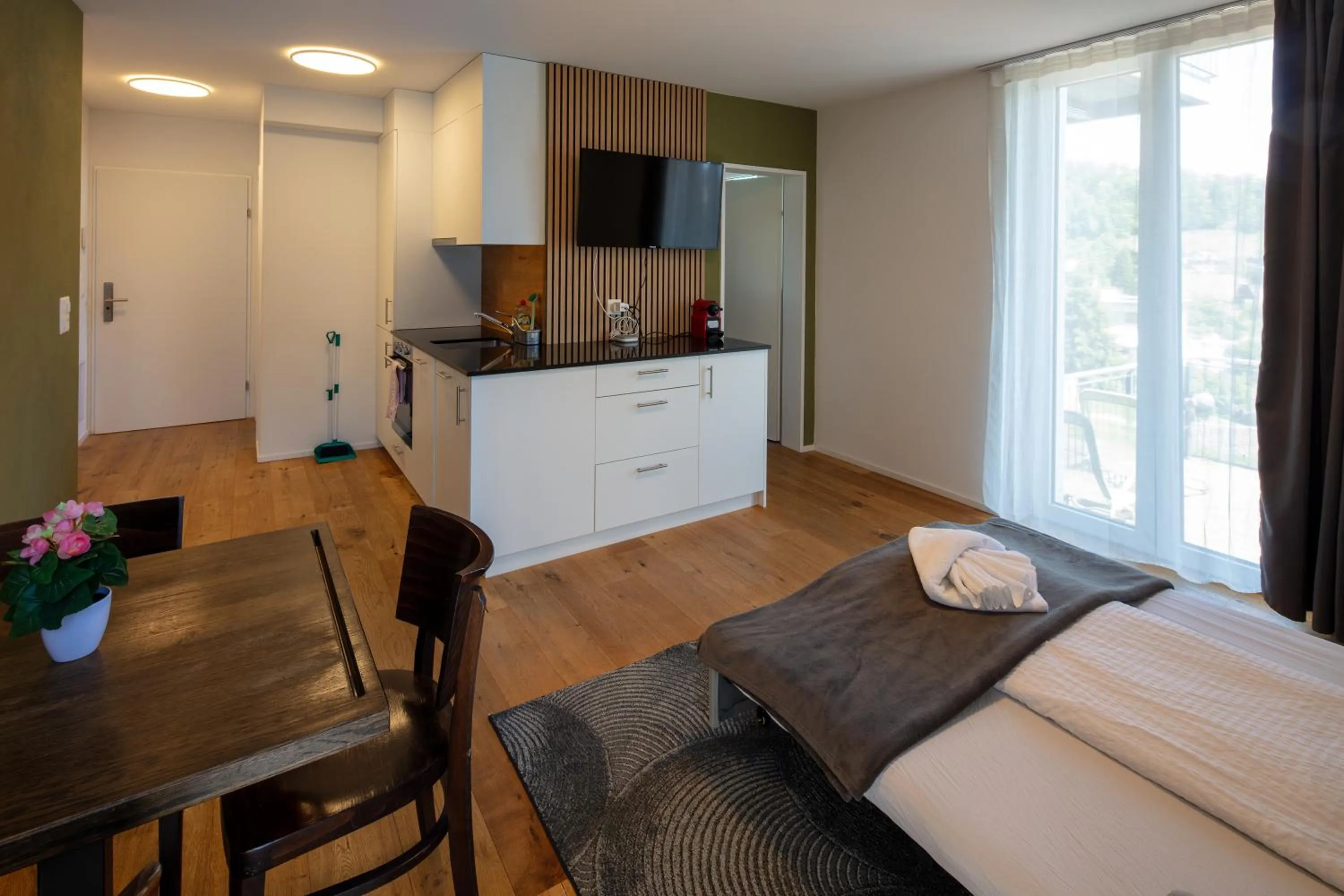 Kitchen or kitchenette, Bed in BERG & BERG APARTMENTS - Spiez Self-Check-in