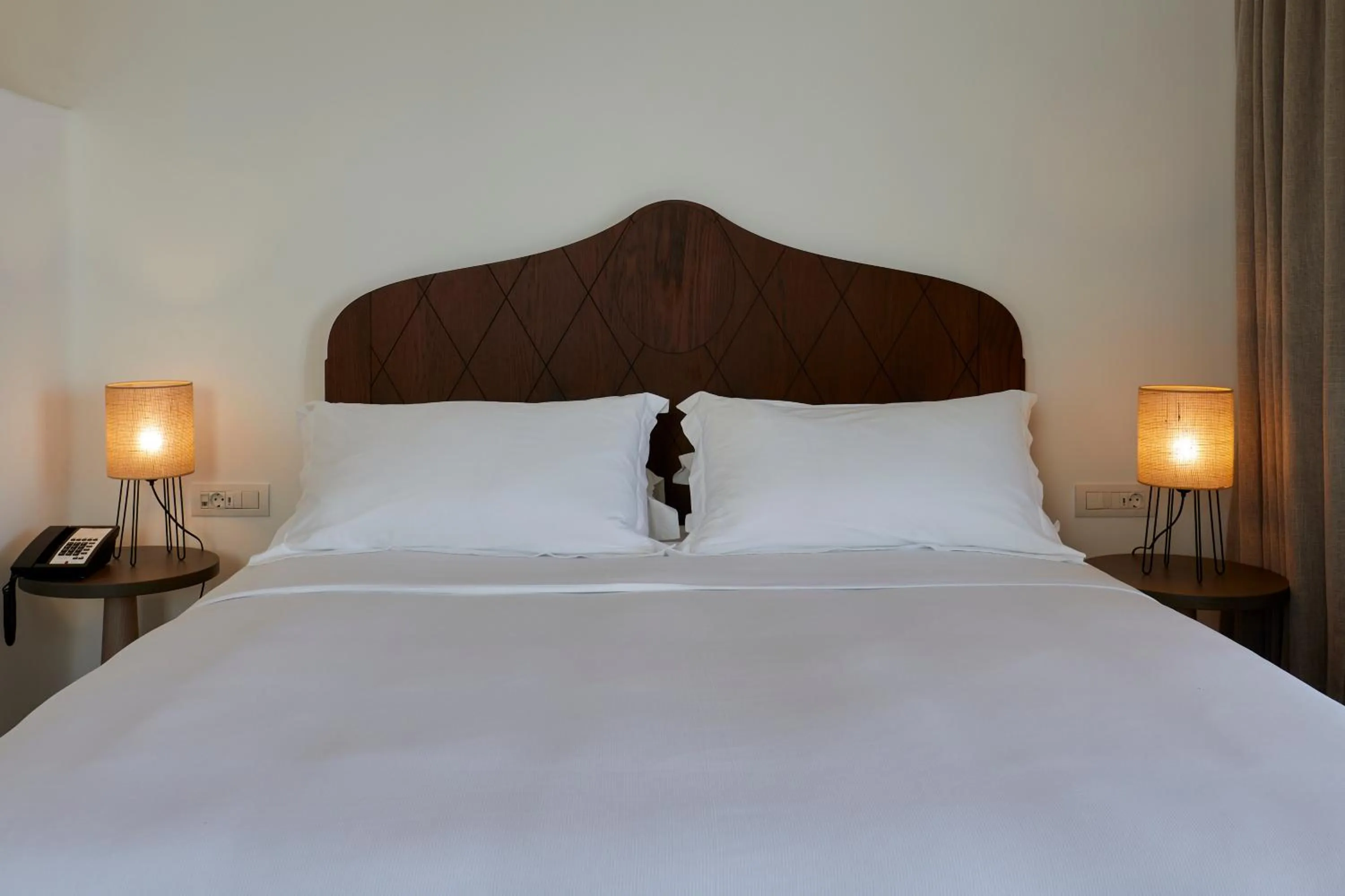 Bed in Sea Breeze Santorini Beach Resort, Curio By Hilton