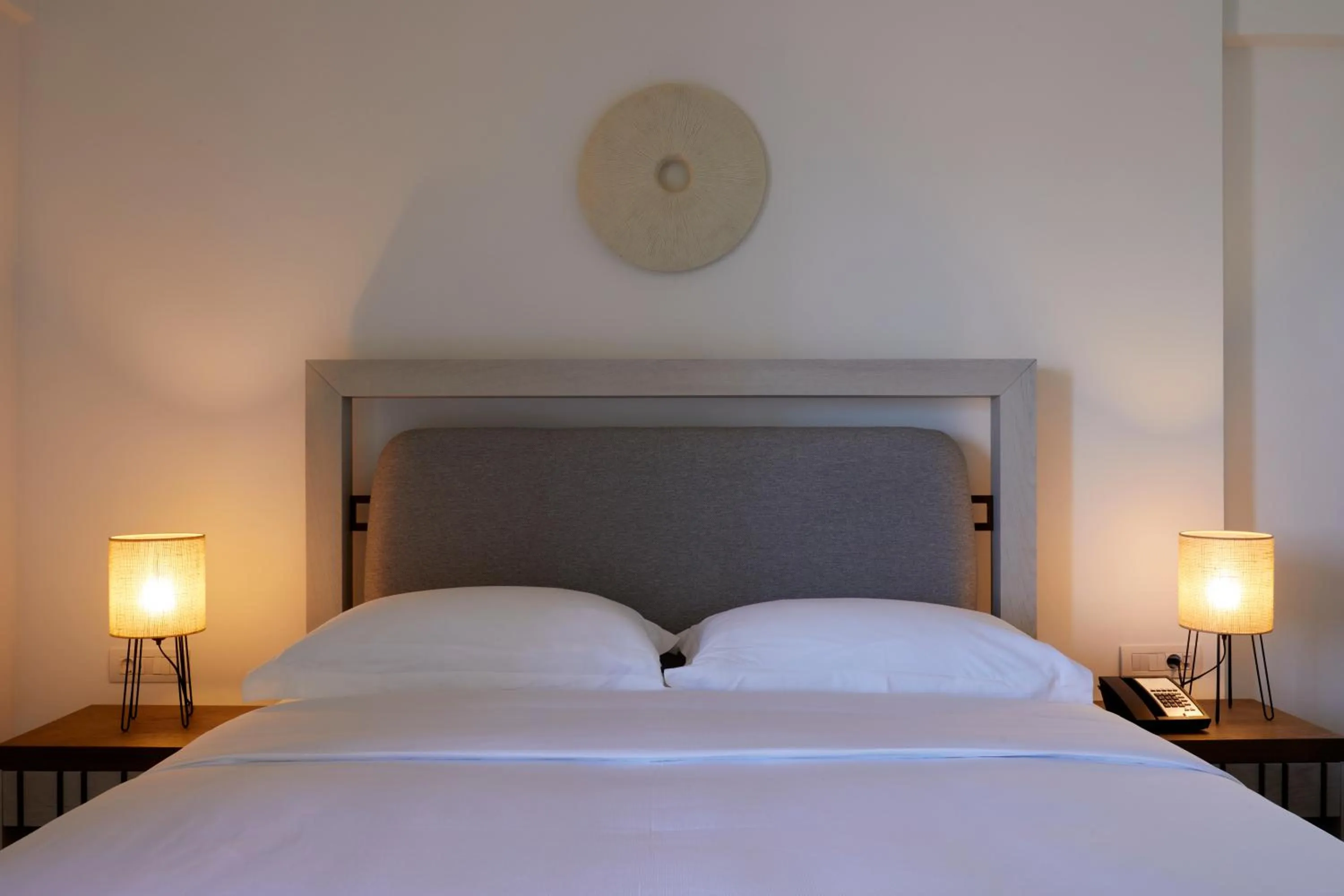 Bed in Sea Breeze Santorini Beach Resort, Curio By Hilton