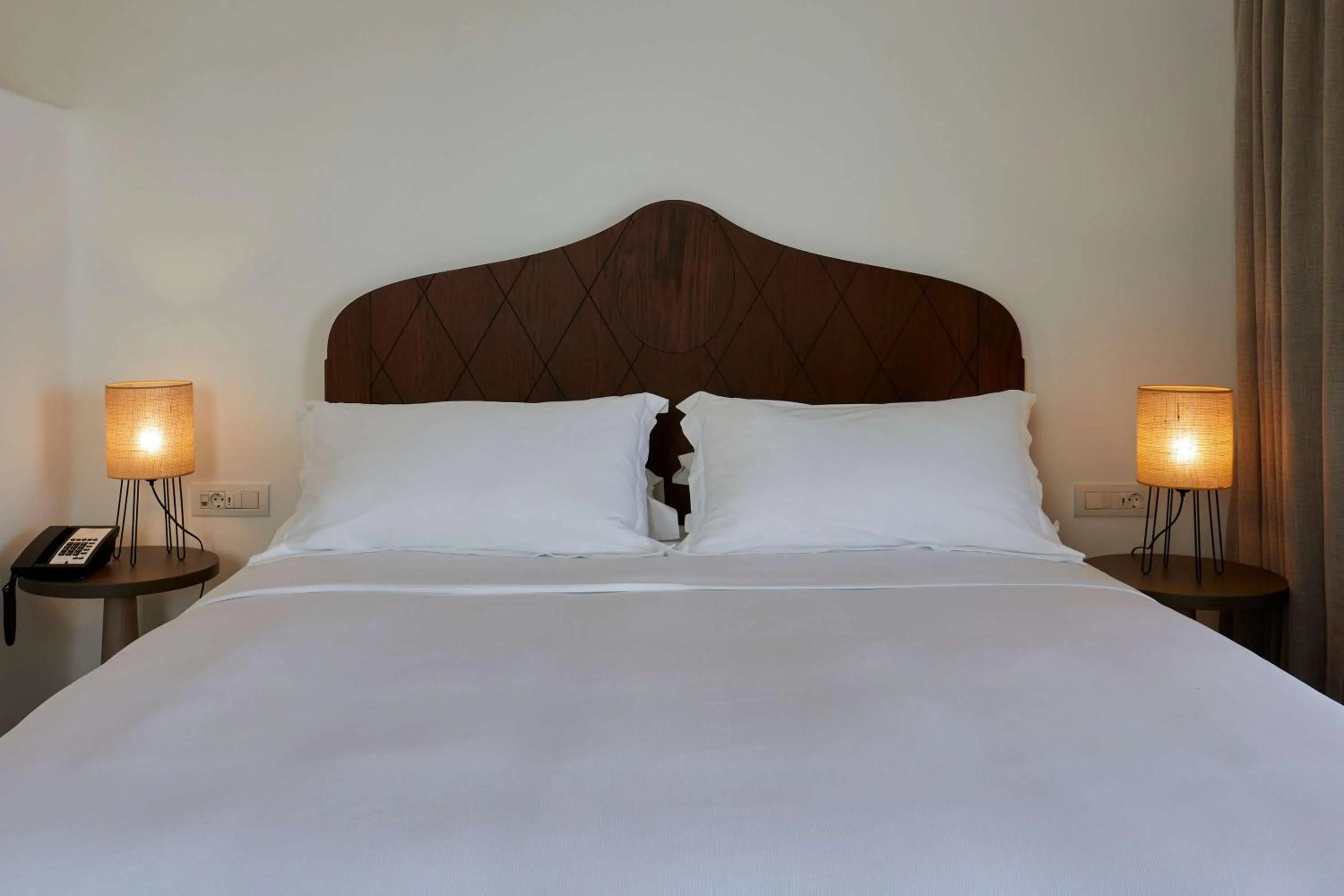 Bed in Sea Breeze Santorini Beach Resort, Curio By Hilton