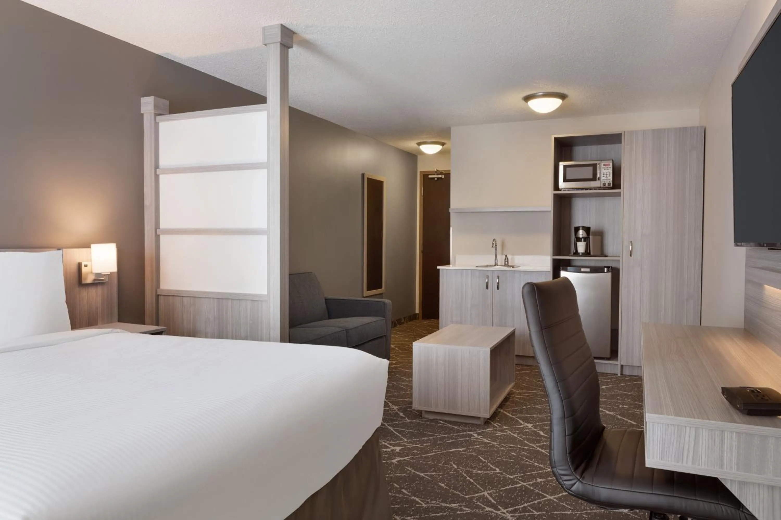 Seating area, Bed in Microtel Inn & Suites by Wyndham Lloydminster