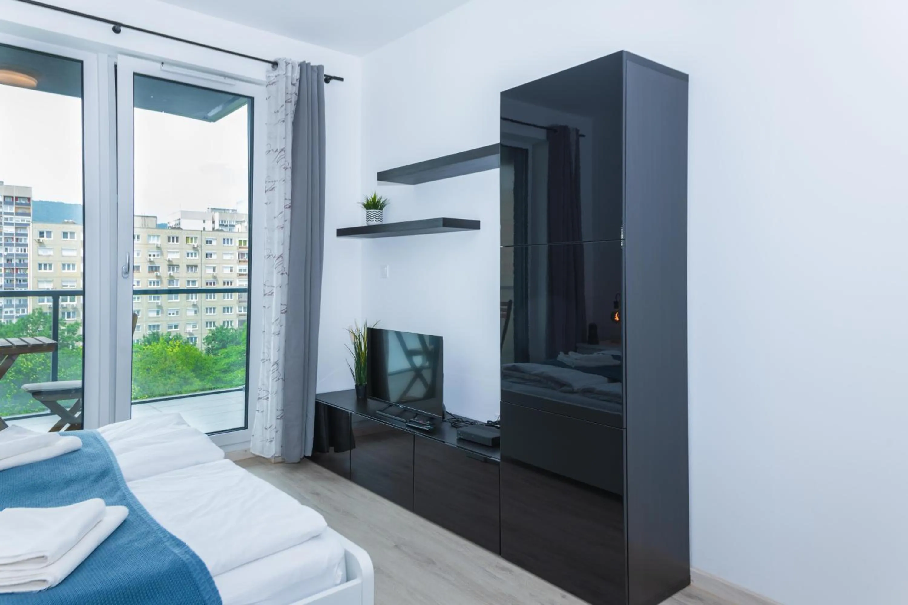 Communal lounge/ TV room, Bed in WaterFront City Apartments by FirstHost